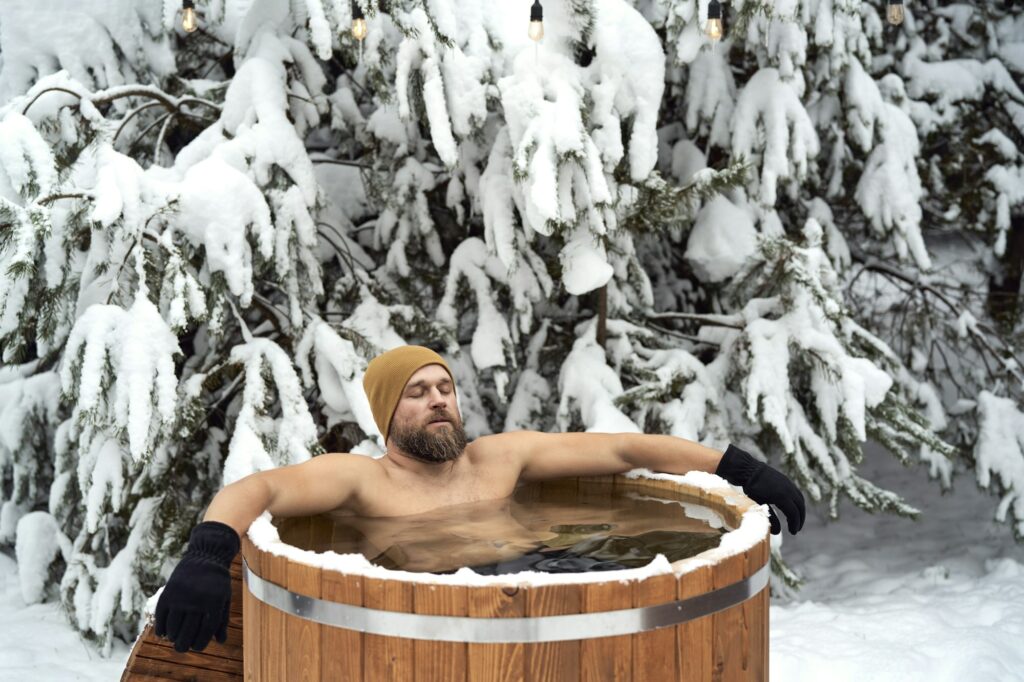 Caucasian man take the winter bath in tube outdoors