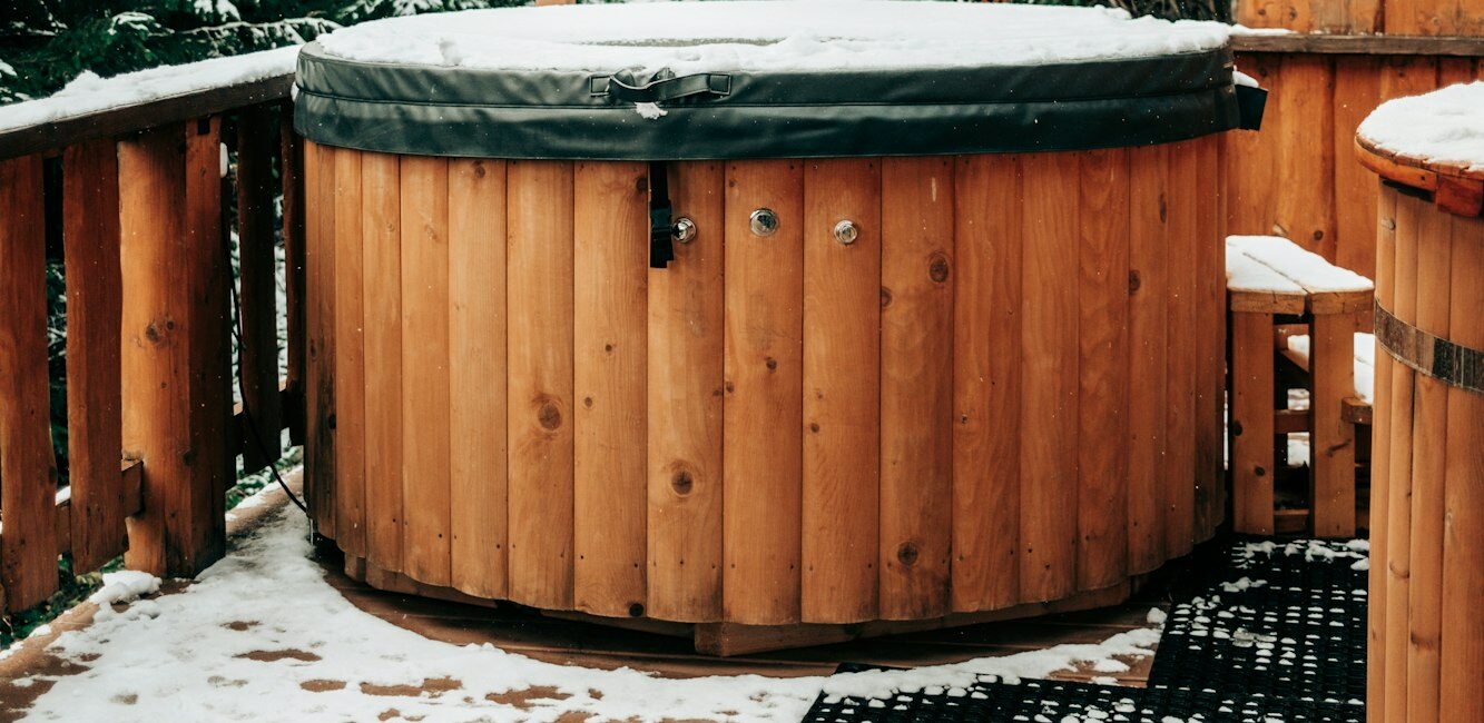 Open-air bath interior near forest, winter, snow view. Wooden hot tub outside