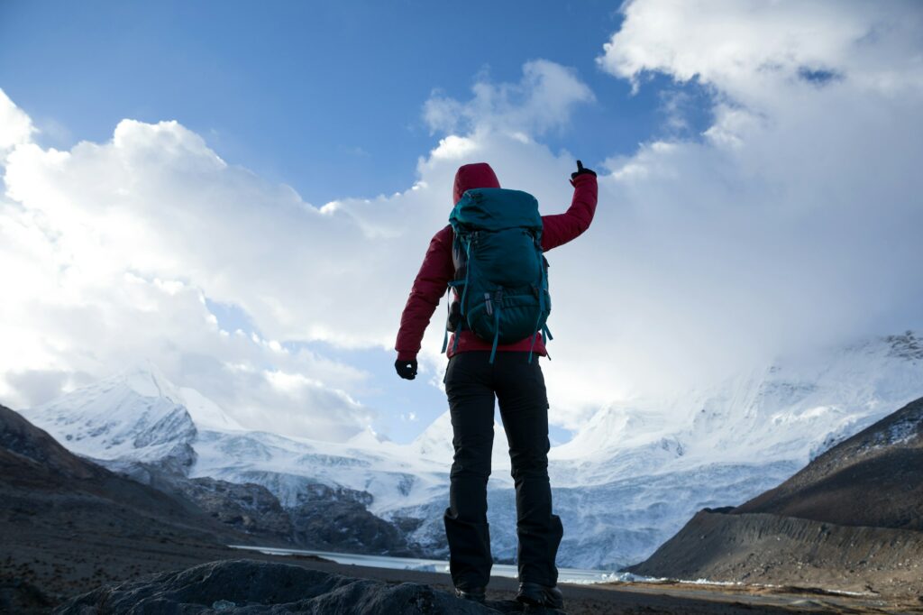 Strong woman backpacker hiking in winter mountains